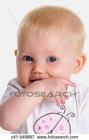 Stock Photo - Portrait of a baby with a finger in her mouth.. Fotosearch