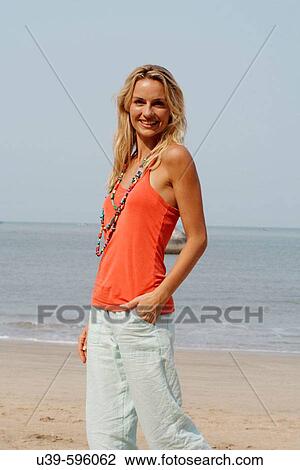 Portrait of a beautiful blonde woman wearing an orange vest and smiling on a beach in India. View Large Photo Image Stock Image - Portrait of a beautiful blonde woman wearing an orange vest and smiling on a beach in India.. Fotosearch