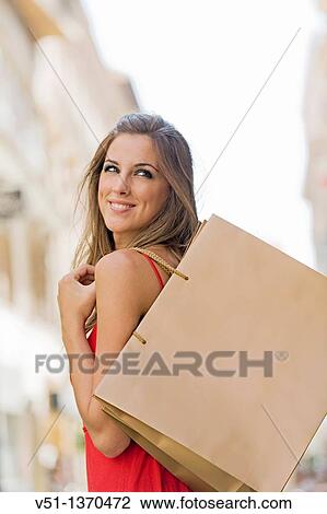 Stock Image - Portrait of a beautiful blonde woman shopping. Fotosearch
