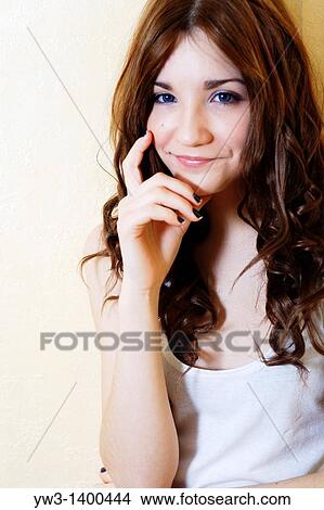 Portrait of a beautiful woman leaning on a wall and smiling View Large Photo Image Picture - Portrait of a beautiful woman leaning on a wall and smiling. Fotosearch