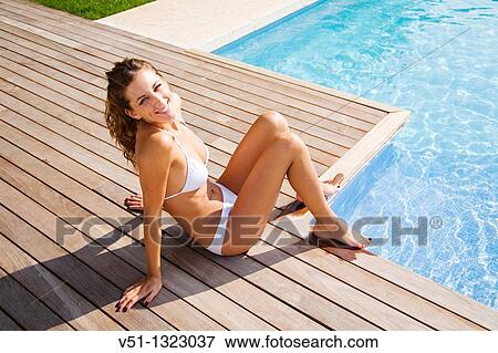 Portrait of a beautiful woman smiling by the pool View Large Photo Image Stock Photo - Portrait of a beautiful woman smiling by the pool. Fotosearch