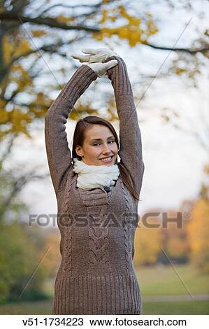 Portrait of a beautiful young woman stretching in the park in Autumn View Large Photo Image Stock Image - Portrait of a beautiful young woman stretching in the park in Autumn. Fotosearch