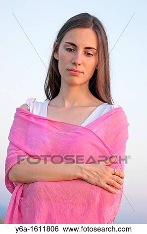 Stock Photograph - Portrait of a beautiful young woman outdoors looking down. Fotosearch