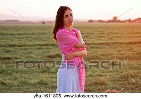 Portrait of a beautiful young woman wearing summer dress standing in field looking away View Large Photo Image Stock Photography - Portrait of a beautiful young woman wearing summer dress standing in field looking away. Fotosearch