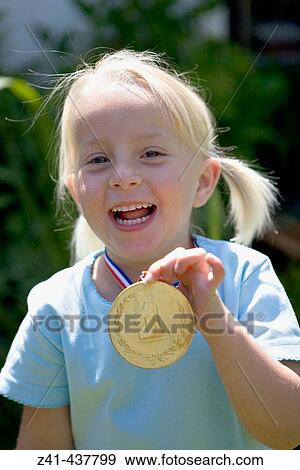 Stock Photo - Portrait of a blond girl with a medal. Fotosearch