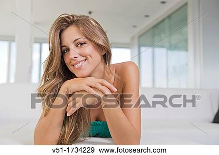 Portrait of a blonde pretty woman smiling at camera at the sofa View Large Photo Image Stock Photo - Portrait of a blonde pretty woman smiling at camera at the sofa. Fotosearch