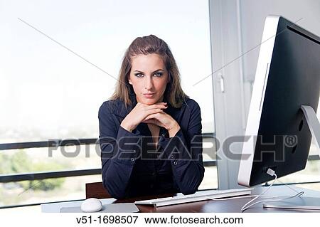 Stock Photo - Portrait of a blonde woman at workplace with the computer. Fotosearch
