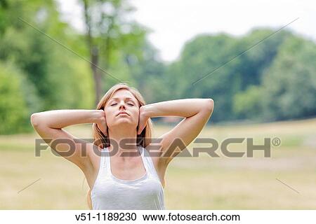 Portrait of a blonde woman covering her ears in the park View Large Photo Image Stock Image - Portrait of a blonde woman covering her ears in the park. Fotosearch