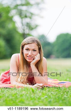 Portrait of a blonde woman laying in the park View Large Photo Image Stock Photograph - Portrait of a blonde woman laying in the park. Fotosearch