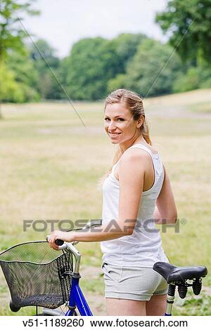 Portrait of a blonde woman riding a bike in the park View Large Photo Image Stock Image - Portrait of a blonde woman riding a bike in the park. Fotosearch