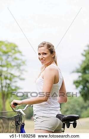 Portrait of a blonde woman riding a bike in the park View Large Photo Image Stock Photo - Portrait of a blonde woman riding a bike in the park. Fotosearch