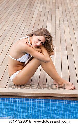 Portrait of a blonde woman sitting by the pool and smiling at camera View Large Photo Image Stock Photo - Portrait of a blonde woman sitting by the pool and smiling at camera. Fotosearch