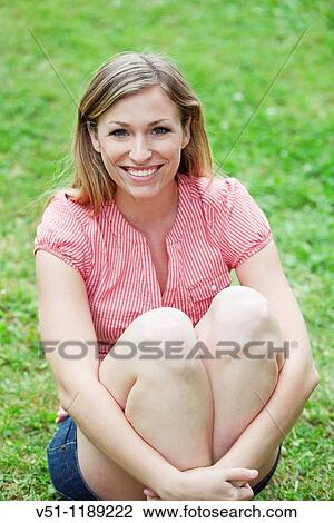 Portrait of a blonde woman sitting in the park and smiling at camera View Large Photo Image Stock Image - Portrait of a blonde woman sitting in the park and smiling at camera. Fotosearch
