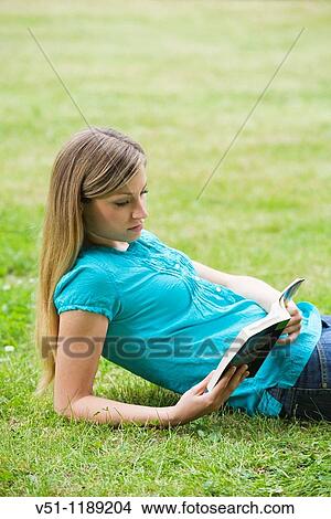 Portrait of a blonde woman with a book in the park View Large Photo Image Picture - Portrait of a blonde woman with a book in the park. Fotosearch