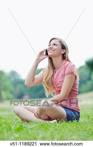 Portrait of a blonde woman with mobile at the park View Large Photo Image Stock Image - Portrait of a blonde woman with mobile at the park. Fotosearch
