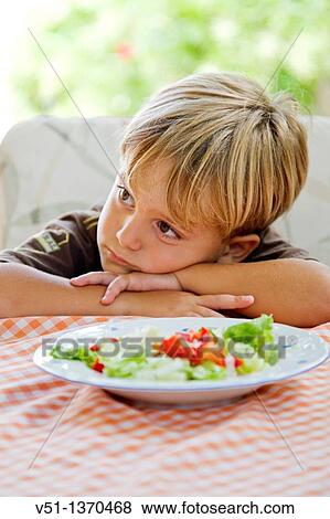 Portrait of a boring boy with a plate of salad View Large Photo Image Stock Photo - Portrait of a boring boy with a plate of salad. Fotosearch