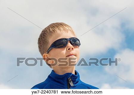 Stock Image - Portrait of a boy wearing sunglasses.. Fotosearch