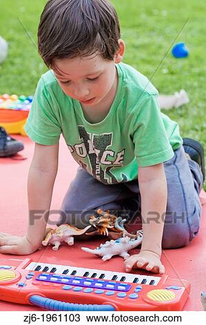 Portrait of a boy with keyboard playing outdoor in the garden. View Large Photo Image Stock Image - Portrait of a boy with keyboard playing outdoor in the garden.. Fotosearch