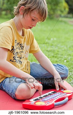 Portrait of a boy with keyboard playing outdoor in the garden. View Large Photo Image Stock Photograph - Portrait of a boy with keyboard playing outdoor in the garden.. Fotosearch
