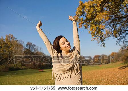 Portrait of a brunette beautiful woman with arms opened in park in Autumn View Large Photo Image Stock Photo - Portrait of a brunette beautiful woman with arms opened in park in Autumn. Fotosearch