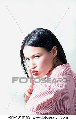 Stock Image - Portrait of a brunette woman asking for silence. Fotosearch