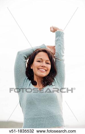 Portrait of a brunette woman breathing fresh air by the sea smiling at camera View Large Photo Image Stock Image - Portrait of a brunette woman breathing fresh air by the sea smiling at camera. Fotosearch