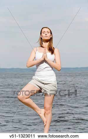Portrait of a brunette woman doing yoga by the sea View Large Photo Image Stock Image - Portrait of a brunette woman doing yoga by the sea. Fotosearch