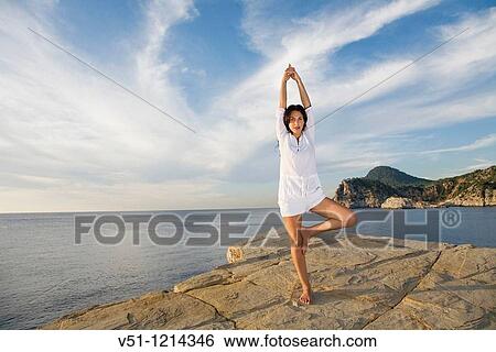 Portrait of a brunette woman doing yoga in a cliff in Ibiza, Balearic Islands View Large Photo Image Stock Photograph - Portrait of a brunette woman doing yoga in a cliff in Ibiza, Balearic Islands. Fotosearch