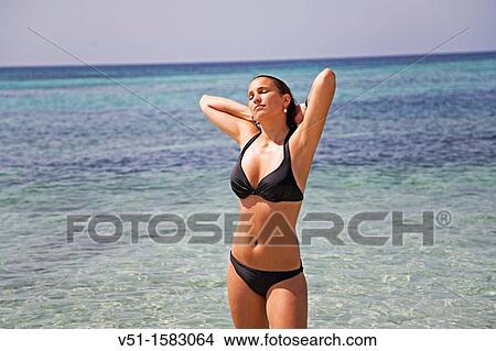 Portrait of a brunette woman holding her hair with eyes closed in Formentera, Balearic Island, Spain View Large Photo Image Picture - Portrait of a brunette woman holding her hair with eyes closed in Formentera, Balearic Island, Spain. Fotosearch