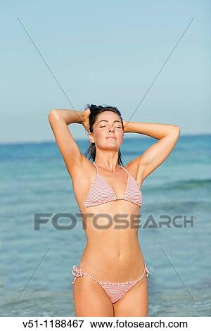 Portrait of a brunette woman holding her hair with eyes closed in Ibiza, Balearic Island View Large Photo Image Stock Photo - Portrait of a brunette woman holding her hair with eyes closed in Ibiza, Balearic Island. Fotosearch