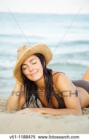 Portrait of a brunette woman laying on the beach in Ibiza, Balearic Islands View Large Photo Image Stock Photography - Portrait of a brunette woman laying on the beach in Ibiza, Balearic Islands. Fotosearch