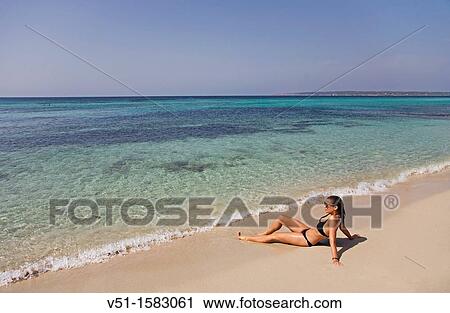 Stock Image - Portrait of a brunette woman relaxing at the beach in Formentera. Fotosearch