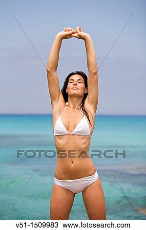 Portrait of a brunette woman stretching at the beach, Formentera, Balearic Islands View Large Photo Image Stock Image - Portrait of a brunette woman stretching at the beach, Formentera, Balearic Islands. Fotosearch