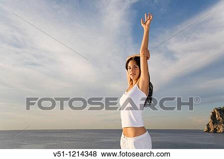 Portrait of a brunette woman stretching in a cliff in Ibiza, Balearic Island View Large Photo Image Stock Photo - Portrait of a brunette woman stretching in a cliff in Ibiza, Balearic Island. Fotosearch