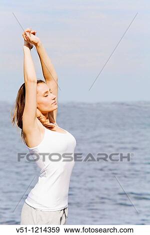 Portrait of a brunette woman stretching by the sea View Large Photo Image Stock Photo - Portrait of a brunette woman stretching by the sea. Fotosearch