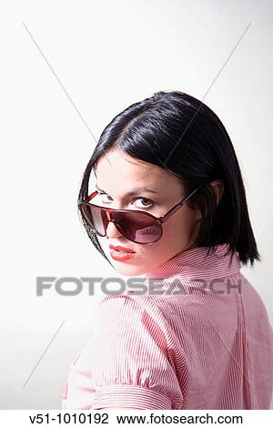 Portrait of a brunette woman with sunglasses in a studio shot View Large Photo Image Stock Image - Portrait of a brunette woman with sunglasses in a studio shot. Fotosearch