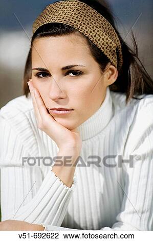Stock Image - Portrait of a brunette young woman in the park. Fotosearch
