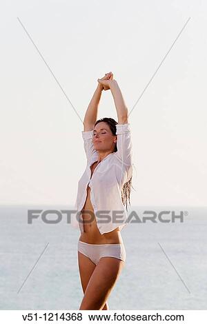 Portrait of a brunnete woman stretching by the sea View Large Photo Image Stock Photo - Portrait of a brunnete woman stretching by the sea. Fotosearch