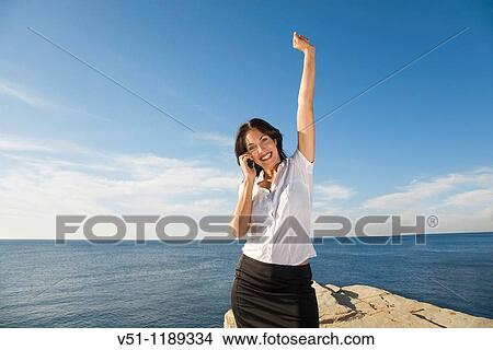 Portrait of a business woman with mobile in a cliff in Ibiza, Balearic Islands View Large Photo Image Picture - Portrait of a business woman with mobile in a cliff in Ibiza, Balearic Islands. Fotosearch