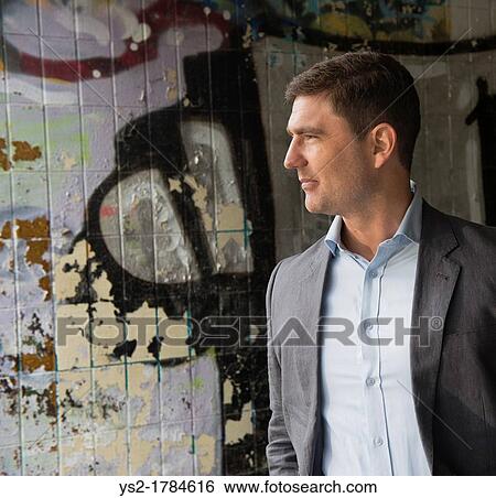 Portrait of a businessman in a walkway covered with grafitti View Large Photo Image Stock Photograph - Portrait of a businessman in a walkway covered with grafitti. Fotosearch