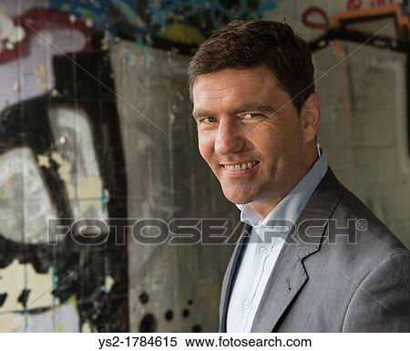 Portrait of a businessman in a walkway covered with grafitti View Large Photo Image Stock Photography - Portrait of a businessman in a walkway covered with grafitti. Fotosearch