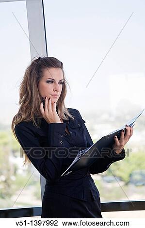 Portrait of a businesswoman with agenda by the window View Large Photo Image Stock Image - Portrait of a businesswoman with agenda by the window. Fotosearch