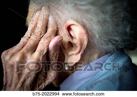 Portrait of a centennial woman in a elderly people home, hand covering her face. View Large Photo Image Picture - Portrait of a centennial woman in a elderly people home, hand covering her face.. Fotosearch
