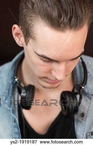 Portrait of a confident and carefree young adult male with earphones View Large Photo Image Stock Photo - Portrait of a confident and carefree young adult male with earphones. Fotosearch