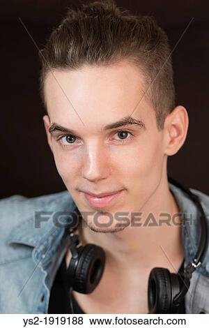 Portrait of a confident and carefree young adult male with earphones View Large Photo Image Stock Photo - Portrait of a confident and carefree young adult male with earphones. Fotosearch