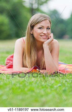 Stock Photo - Portrait of a content blonde woman in the park. Fotosearch