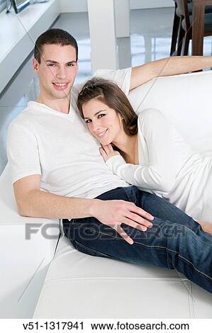 Portrait of a couple at home relaxing in the sofa View Large Photo Image Stock Image - Portrait of a couple at home relaxing in the sofa. Fotosearch