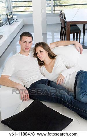 Portrait of a couple at home relaxing in the sofa View Large Photo Image Stock Photo - Portrait of a couple at home relaxing in the sofa. Fotosearch