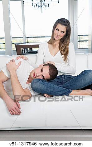 Portrait of a couple at home relaxing in the sofa View Large Photo Image Stock Photograph - Portrait of a couple at home relaxing in the sofa. Fotosearch
