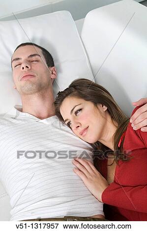 Stock Photo - Portrait of a couple chilling in sofa. Fotosearch